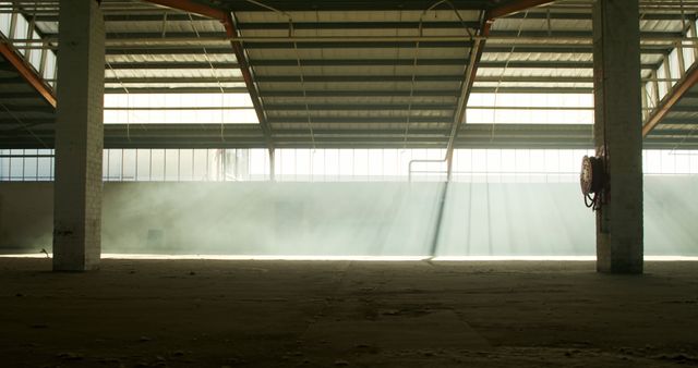 A sunlit abandoned warehouse interior filled with grey smoke from a smoke grenade - Download Free Stock Photos Pikwizard.com