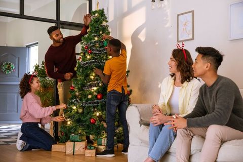Diverse Family Decorating Christmas Tree in Living Room Full of Joy
