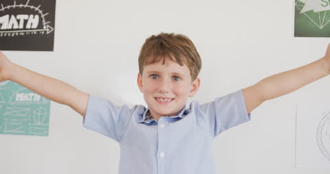 Joyful Boy with Outstretched Arms in Classroom Celebrating Success