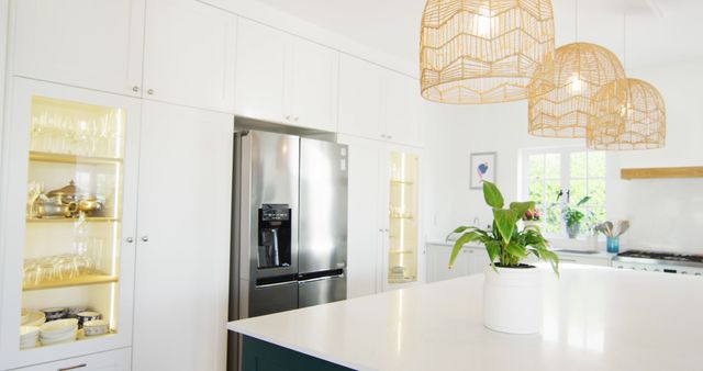 Image of modern, domestic kitchen with fridge freezer, hanging lamps over central island, copy space. Interior design and domestic life.