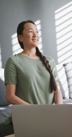 Smiling Asian Woman Working from Home with Laptop