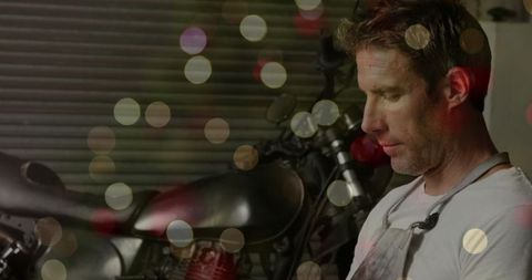 Mechanic Adjusting Motorcycle Tank in Industrial Garage