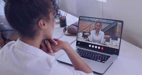Woman joining remote video meeting on laptop in bright minimalist home office, collaborating