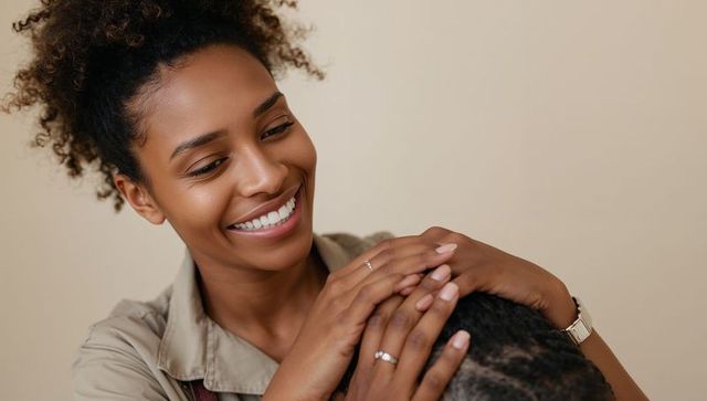 Smiling woman resting hands gently on partner's head showing tenderness and warmth