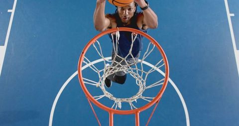 Dynamic slam dunk on vibrant blue outdoor sports court