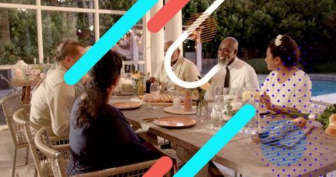 Multi-Generational Family Gathering Enjoying Outdoor Evening Dinner by Pool
