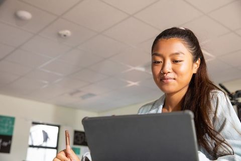 Student in Modern Classroom Studying On Laptop With Focus