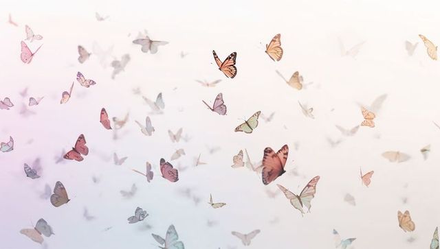 Drifting pastel butterflies creating ethereal flight over soft gradient