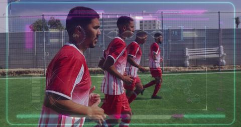 image depicts a group of diverse male footballers in modern sports training, enhanced by digital data overlay indicating use of technology to track performance. ideal for illustrating concepts of sports technology and data analytics in athletics. can be used for articles, blogs, or presentations on innovative training techniques, fitness monitoring, or the intersection of technology and sports.
