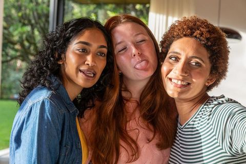 Diverse Women Friends Bonding in Sunlit Room with Garden View