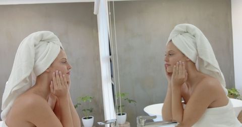 Woman Enjoying Skincare Routine at Mirror with Towel Wrap