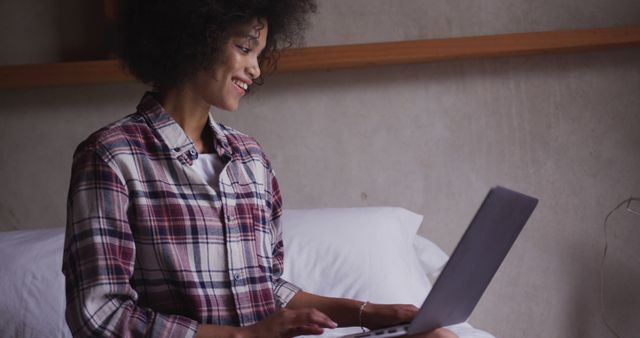 Happy Woman With Curly Hair Using Laptop On Bed - Download Free Stock Images Pikwizard.com