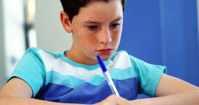 Focused Young Student Writing Notes in Classroom - Download Free Stock Images Pikwizard.com