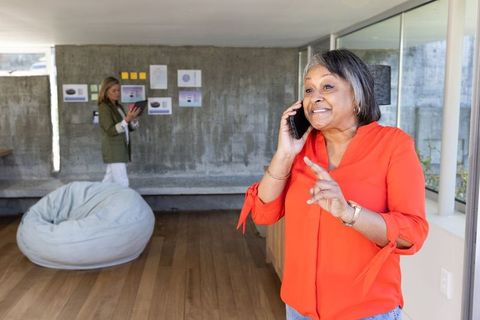 Diverse female coworkers communicating in modern workspace with charts