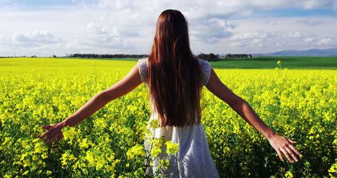 Woman Embracing Nature in Vibrant Rapeseed Field