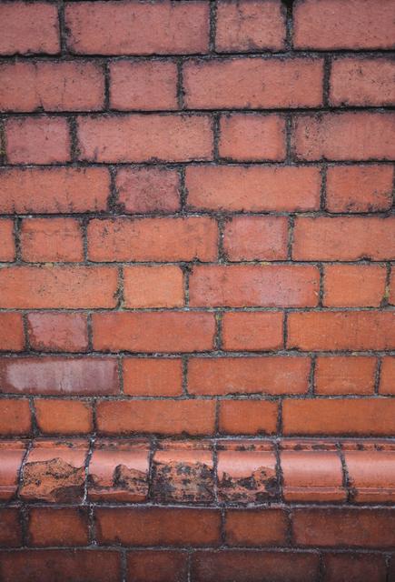 Red brick wall with weathered texture, ideal for use in architectural designs, construction themes, or urban backgrounds. Perfect for adding a rustic or vintage feel to projects, presentations, or websites.
