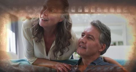 Joyful Senior Couple Relaxing at Home with TV Entertainment