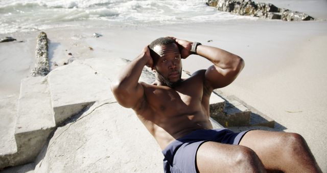 Athlete performing crunches on beach during workout session - Download Free Stock Images Pikwizard.com