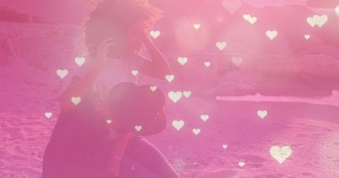 Romantic Hearts Overlaying Diverse Couple Outdoors at Sunset