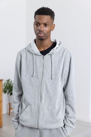 Casualwear Comfort: Man in Grey Hoodie Relaxing Indoors