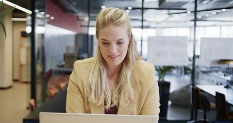 Confident Businesswoman Using Laptop in Modern Office