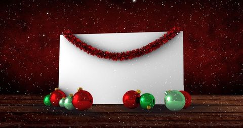 Christmas card with baubles during snowfall