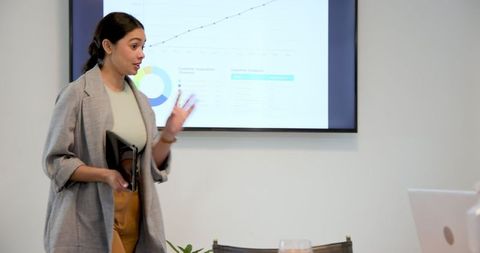 Confident businesswoman presenting in modern meeting room