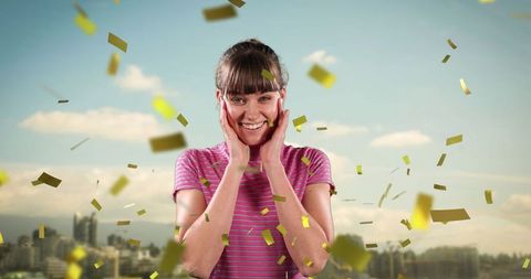 Joyful Woman Celebrating on Rooftop with Gold Confetti