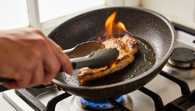 Searing chicken breast in nonstick skillet with flame flare-up on gas stove