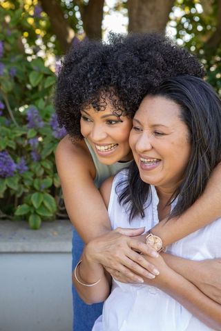 Diverse Mother and Daughter Hugging Outdoors in Surprise