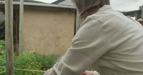 Senior Woman Gardening and Watering Plants on Overcast Day