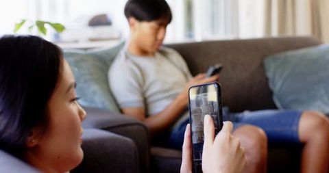 Couple relaxing and browsing smartphones