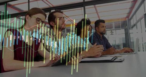 Multicultural team analyzing financial charts during collaborative office meeting