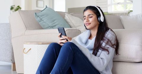 Woman Relaxing with Headphones and Smartphone at Home