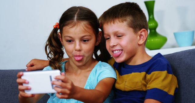 Siblings Making Silly Faces While Taking a Selfie Indoors - Download Free Stock Images Pikwizard.com