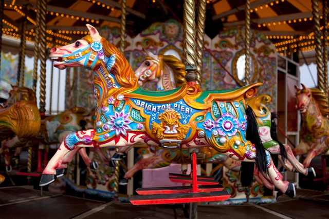 Carousel horse painted in vibrant colors at Brighton Pier. Ideal for themes related to amusement parks, vintage fair rides, childhood nostalgia, and entertainment. Great for use in travel promotions, children's event materials, and nostalgic-themed design projects.