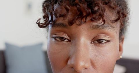 Closeup portrait african woman holding calm neutral gaze showcasing natural skin texture