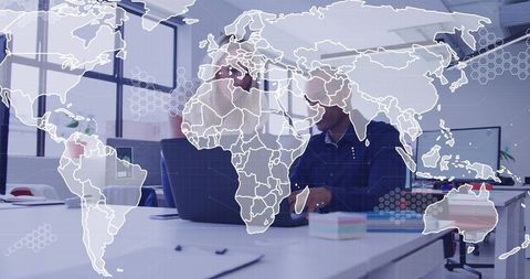 Global team reviewing data on laptop with world map overlay in modern office collaboration