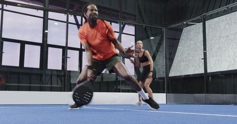 Diverse Athletes Engaging in Intense Action on Indoor Padel Court