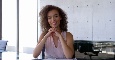 Confident Businesswoman Smiling at Office Desk with Documents
