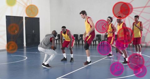 Dribbling through defense during indoor basketball drill with strategy overlay, team uniforms