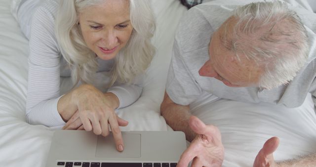 Senior Couple Using Laptop on Bed and Having Discussion - Download Free Stock Photos Pikwizard.com