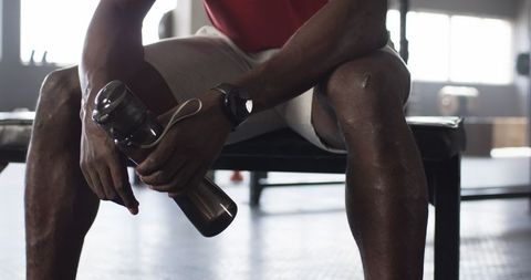 Athletic Man Resting After Workout Holding Water Bottle