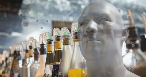 Virus particles around head amidst bottles in bar
