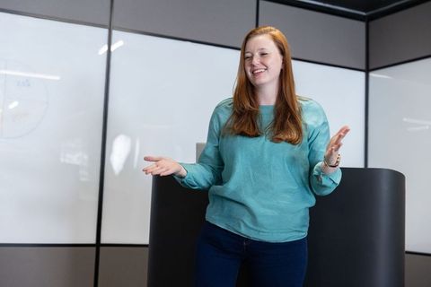 Female Presenter Engaging Audience in Modern Corporate Training Room