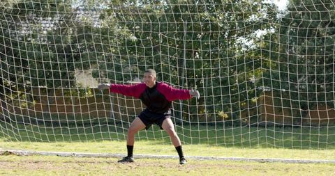 Male goalkeeper ready to defend on outdoor soccer field