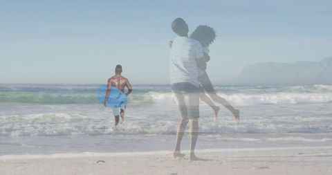 Couple Embracing on Sandy Beach with Surfer in Distance