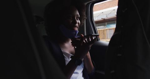 Woman speaking on phone with face mask in city car ride