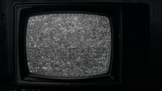 Vintage CRT Television with Static in Dark Room