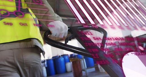Warehouse worker operating pallet jack with magenta analytics overlay and blue drums